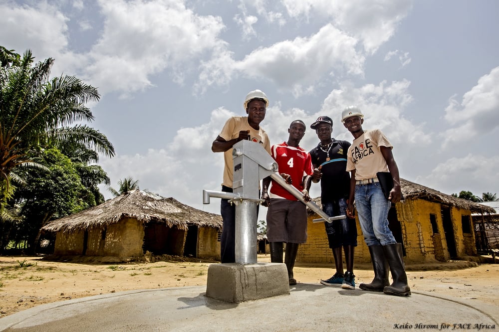 A group of FACE Africa volunteers around a water pump