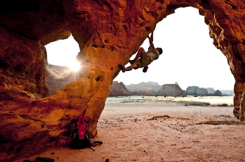 Climber free climbing rock arch 